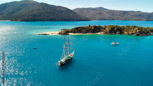 Sailing ship near the shoreline of a beautiful tropical island, aerial view