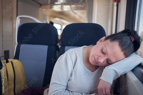 Woman sleeping in a train seat while travelling.