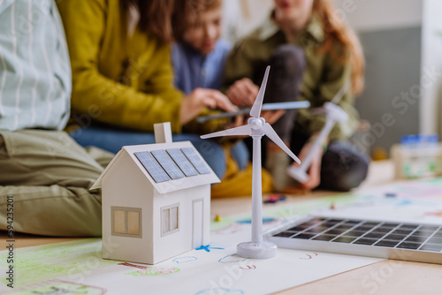 Close-up of house model with solar system and wind turbine during a school lesson. photo