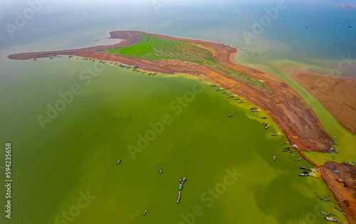 Tri An lake, Dong Nai province, Vietnam in the green algae season has a beautiful green color. Fishing boats come ashore