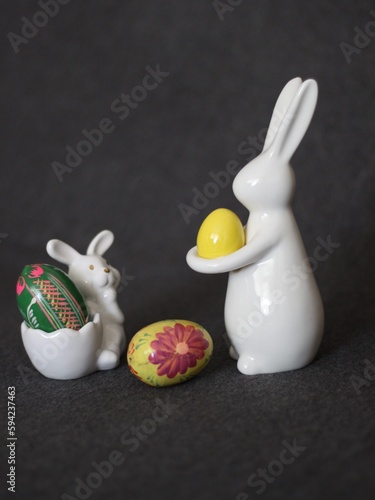 zajączki Wielkanocne, z kolorowymi jajkami na ciemnym tle