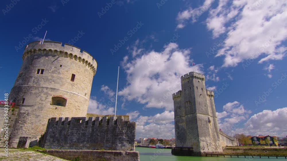 Time Lapse of the harbor in La Rochelle France. The famous French city on the ocean. Sunny summer day, clouds are moving in the background. Crowds of tourists walk the streets Time Lapse of the harbor in La Rochelle France. The famous French city on the ocean. Sunny summer day, clouds are moving in the background. Crowds of tourists walk the streets