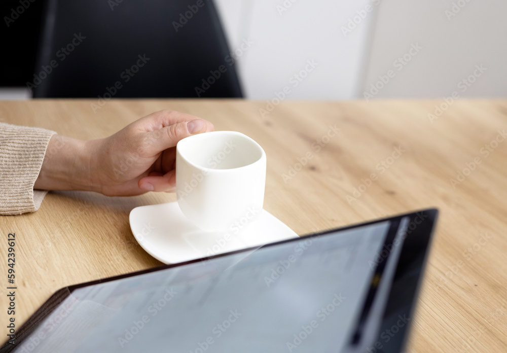 woman drinking coffee and using tablet pad sitting at kitchen table modern home house interior.close up white cup sugar holder. female order something online,shopping at home,sales,delivery concept. woman drinking coffee and using tablet pad sitting at kitchen table modern home house interior.close up white cup sugar holder. female order something online,shopping at home,sales,delivery concept.