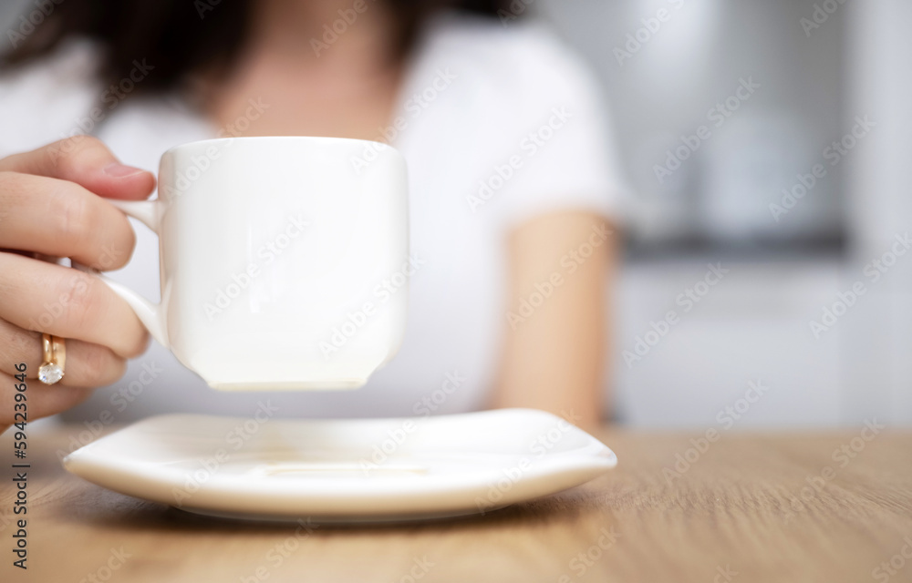 woman drinking coffee and using tablet pad sitting at kitchen table modern home house interior.close up white cup sugar holder. female order something online,shopping at home,sales,delivery concept. woman drinking coffee and using tablet pad sitting at kitchen table modern home house interior.close up white cup sugar holder. female order something online,shopping at home,sales,delivery concept.
