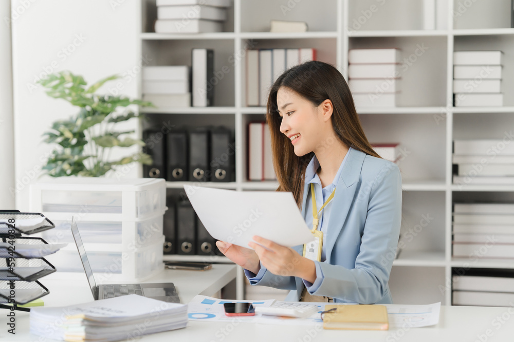 Asian businesswoman in formal suit in office happy and cheerful during using smartphone and working Asian businesswoman in formal suit in office happy and cheerful during using smartphone and working