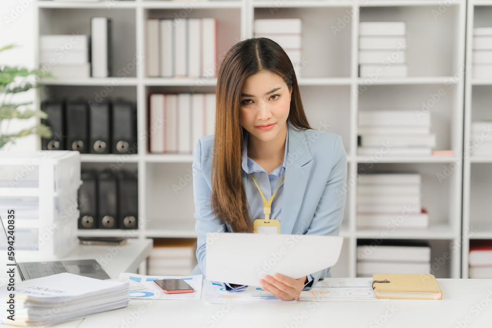 Asian businesswoman in formal suit in office happy and cheerful during using smartphone and working Asian businesswoman in formal suit in office happy and cheerful during using smartphone and working