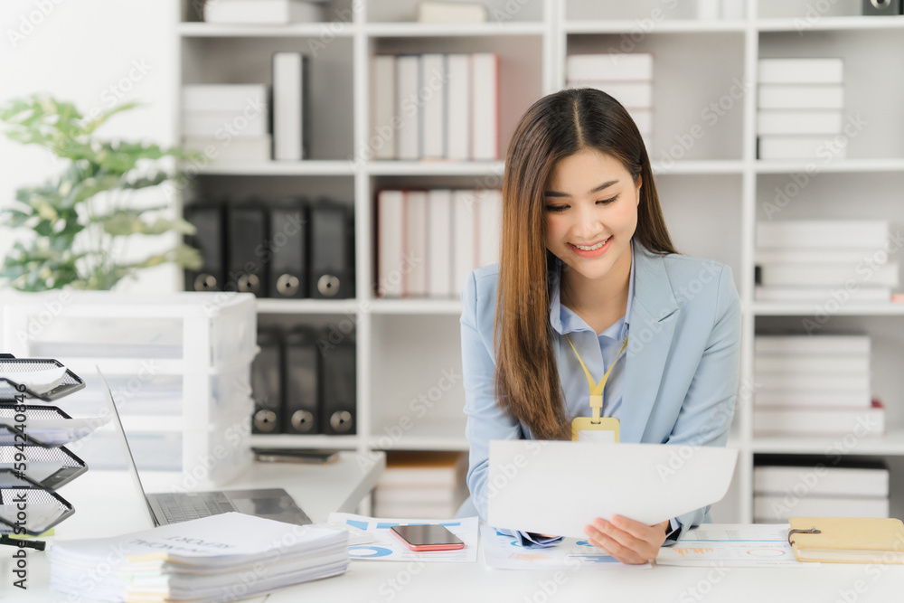 Asian businesswoman in formal suit in office happy and cheerful during using smartphone and working Asian businesswoman in formal suit in office happy and cheerful during using smartphone and working