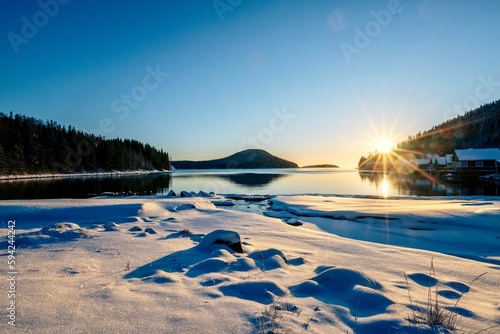 Stunning winter landscape featuring a pristine lake surrounded by snow-covered trees © Photokrisan/Wirestock Creators
