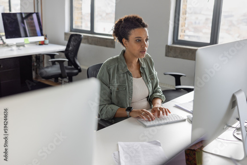 Pregnant businesswoman working at a desktop computer in an office photo