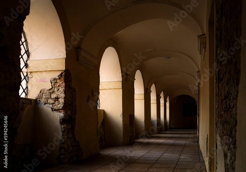 Obraz na plátne Interior view of a cloister featuring a long hallway with archways and pillars in Poznan