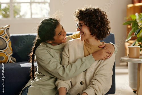 Photos African American happy teenage girl embracing her foster mom while they spending