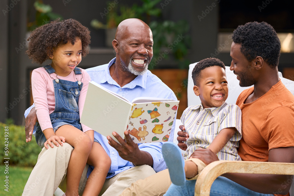 Smiling Multi-Generation Family Reading Book In Garden Together Smiling Multi-Generation Family Reading Book In Garden Together