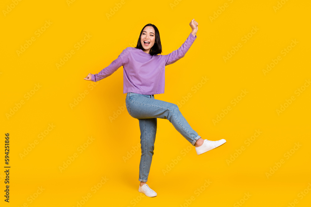 Full length photo of adorable funky lady dressed purple shirt dancing having fun isolated yellow color background