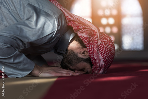 Arabic Muslim Man Making Traditional Prayer To God While Wearing traditonal arabic clothes during ramadan photo
