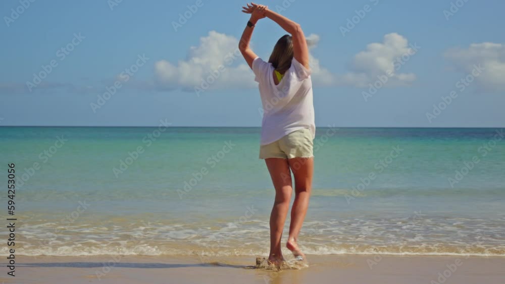 Girl spinning with happiness on the shore of the blue sea Girl spinning with happiness on the shore of the blue sea