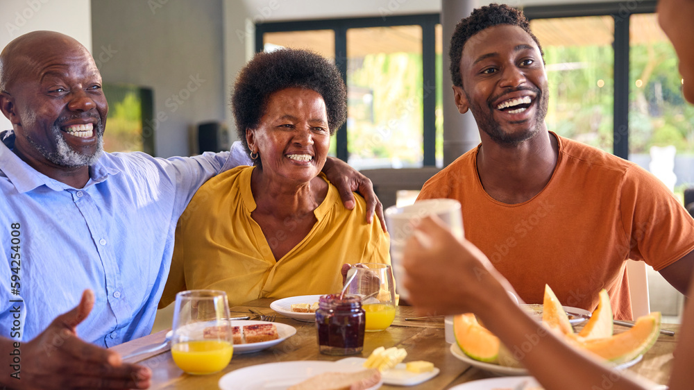 Family Shot With Senior Parents And Adult Offspring At Breakfast Around Table At Home Family Shot With Senior Parents And Adult Offspring At Breakfast Around Table At Home