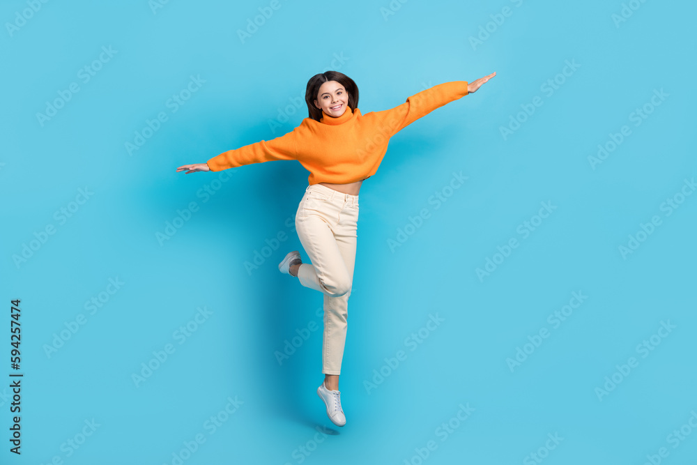 Full body portrait of crazy overjoyed person jumping arms wings flying isolated on blue color background
