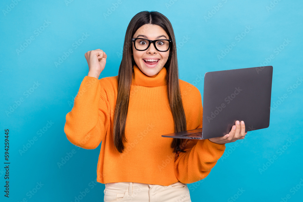 Photo of impressed cheerful girl with long hairstyle wear knit turtleneck hold laptop passed exam isolated on blue color background