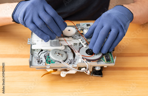 a man repairs and solders microcircuits for household appliances