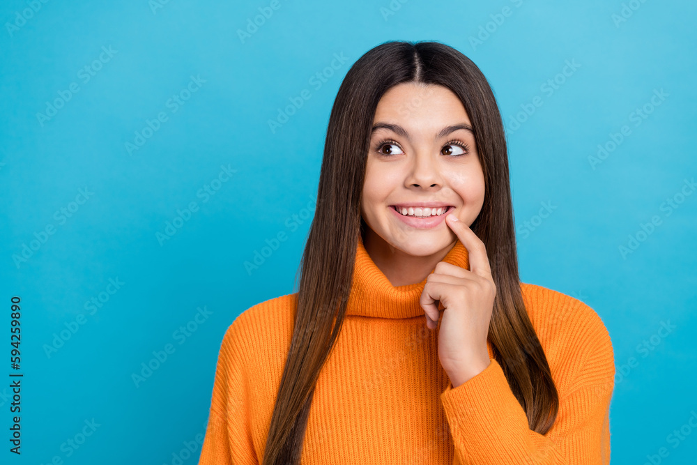 Portrait of positive creative girl finger touch lips beaming smile look empty space isolated on blue color background Portrait of positive creative girl finger touch lips beaming smile look empty space isolated on blue color background