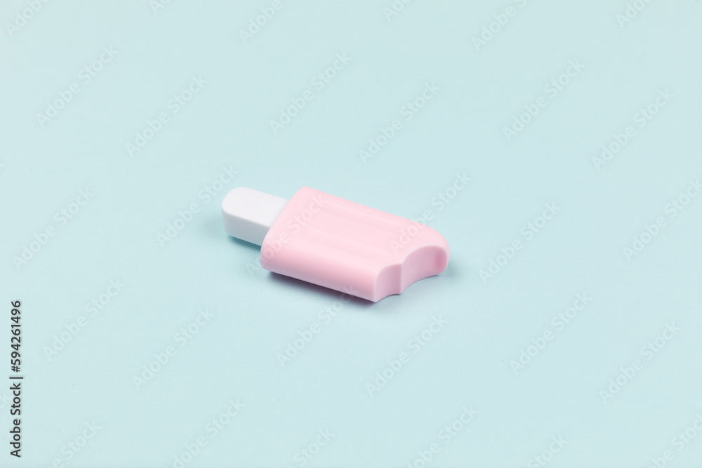 closeup of a pink popsicle on cyan surface icecream closeup of a pink popsicle on cyan surface icecream