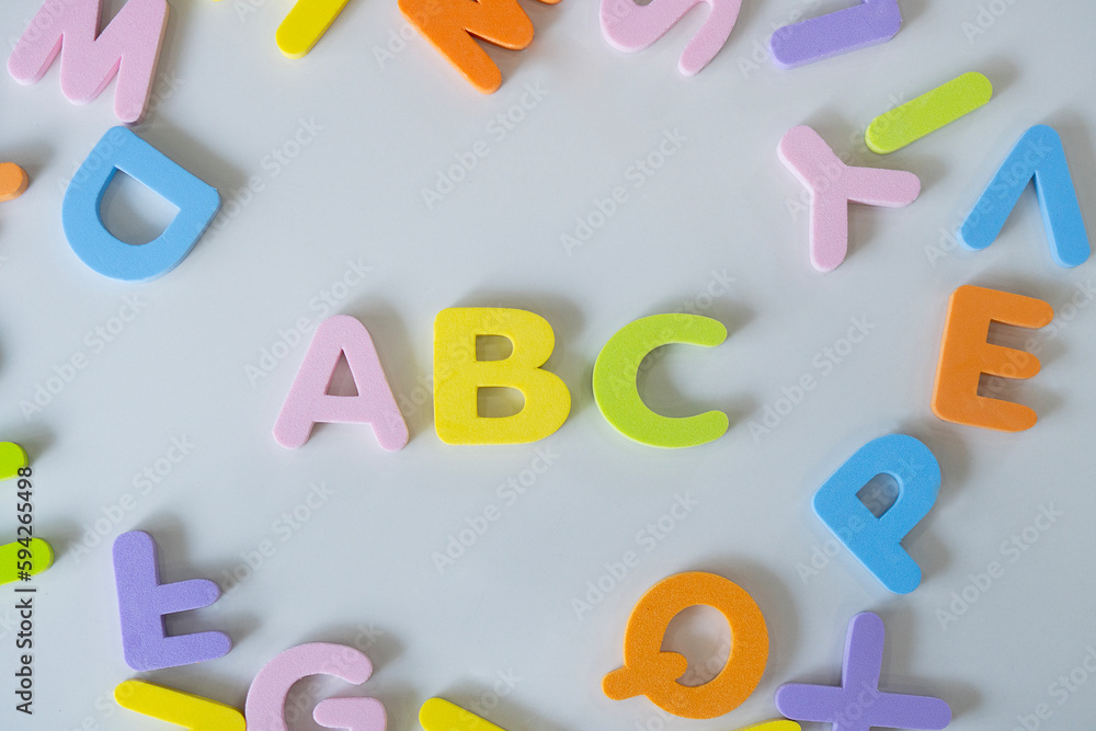 Fototapeta premium Colorful letters A, B, C and toy building block on white background. Concept of education.