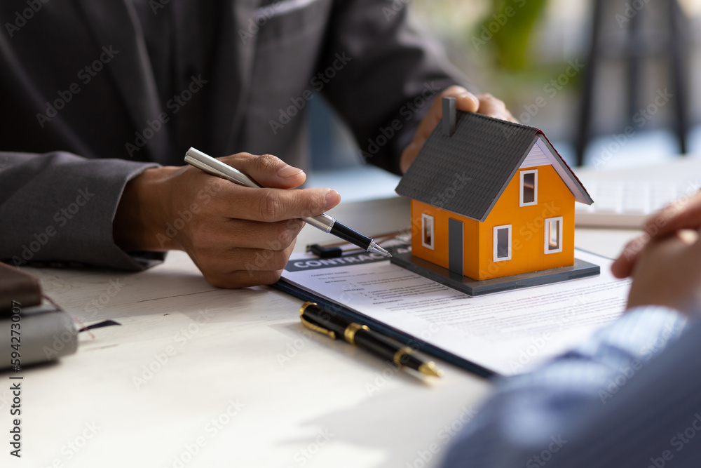 Real estate agent discuss about the terms of the home purchase agreement and asked the customer to sign the documents to make the contract legally, Home sales, lease, mortgage and home insurance. Real estate agent discuss about the terms of the home purchase agreement and asked the customer to sign the documents to make the contract legally, Home sales, lease, mortgage and home insurance.