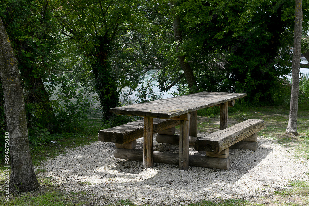 wooden picnic table with tree in the background