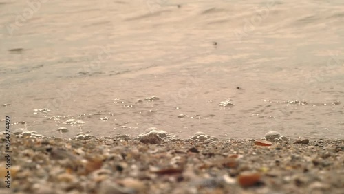 Wallpaper Mural Rocky river bank with small rocks on sand close up with waves running over it. Beautiful sea waves. Sand and amazing river. Water texture. Tranquil, meditation background. Top view. Natural Background Torontodigital.ca