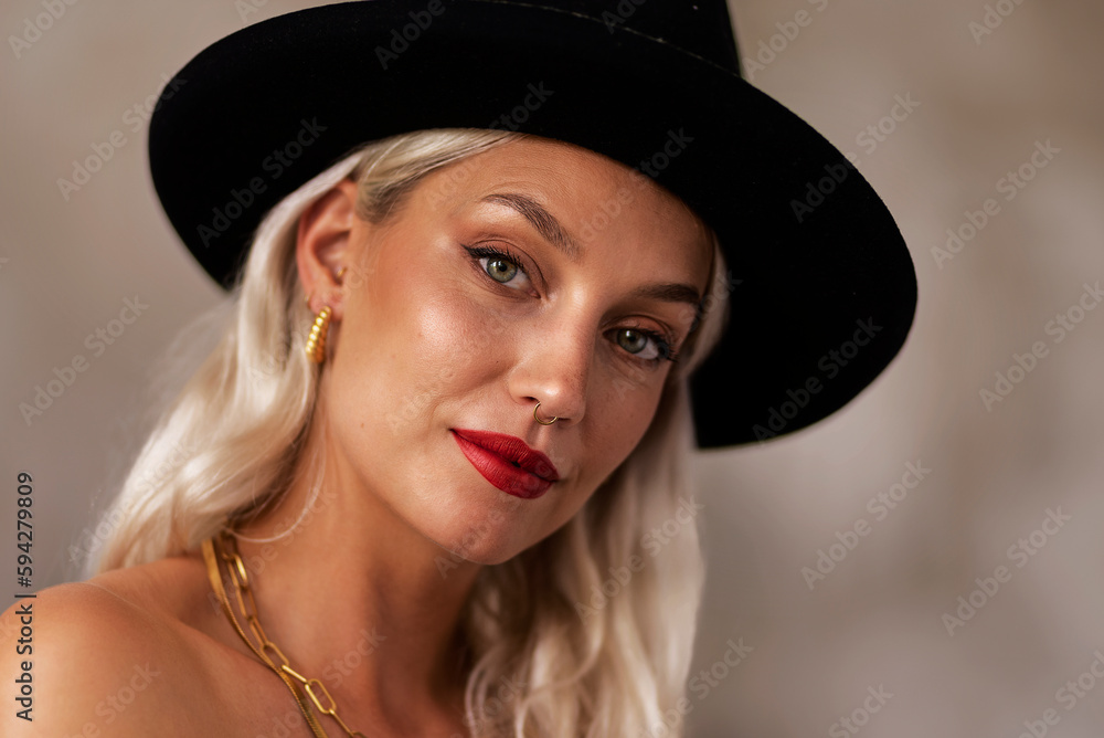 Headshot of a blond haired young woman wearing black hat and red lipstick Headshot of a blond haired young woman wearing black hat and red lipstick