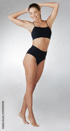 Looking fit and feeling fabulous. Studio shot of an attractive young woman posing in her underwear against a grey background.