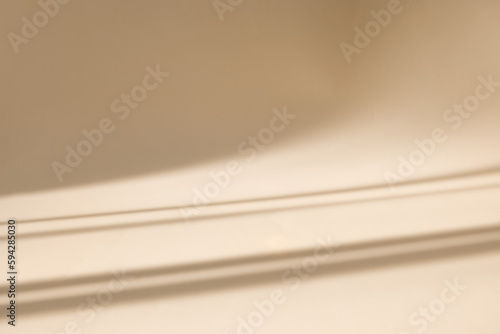 Abstract pastel beige wall background with shadows of window. Empty studio for product presentation. Display product with blurred backdrop. photo