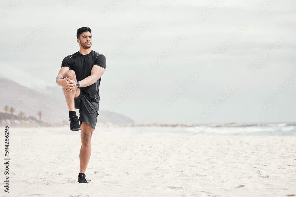 Stretch your day by starting it with a workout. a young man stretching on the beach. Stretch your day by starting it with a workout. a young man stretching on the beach.