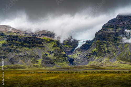 Wonderful moss covered cliffs bordering the road, glacier coming down from the mountains, right after the storm, South Iceland. © David