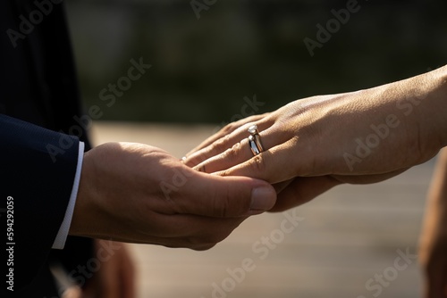 Closeup of the bride and groom holding hands. © Ionut Dragoi/Wirestock Creators