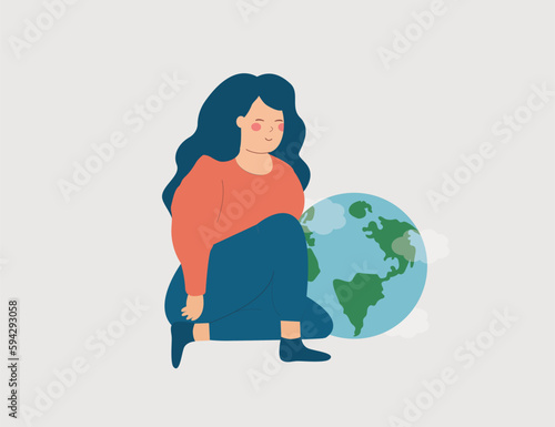 White Woman sits near the green world globe to protect it. Activist Strong Caucasian female cares about the planet and the climate change. Concept of Earth day, renewable power and sustainable energy.