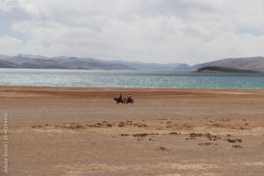 Two Tibetan men riding horses