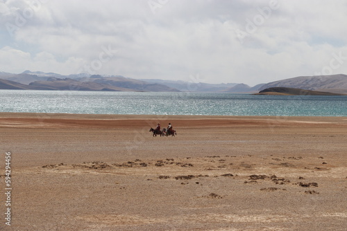 Two Tibetan men riding horses