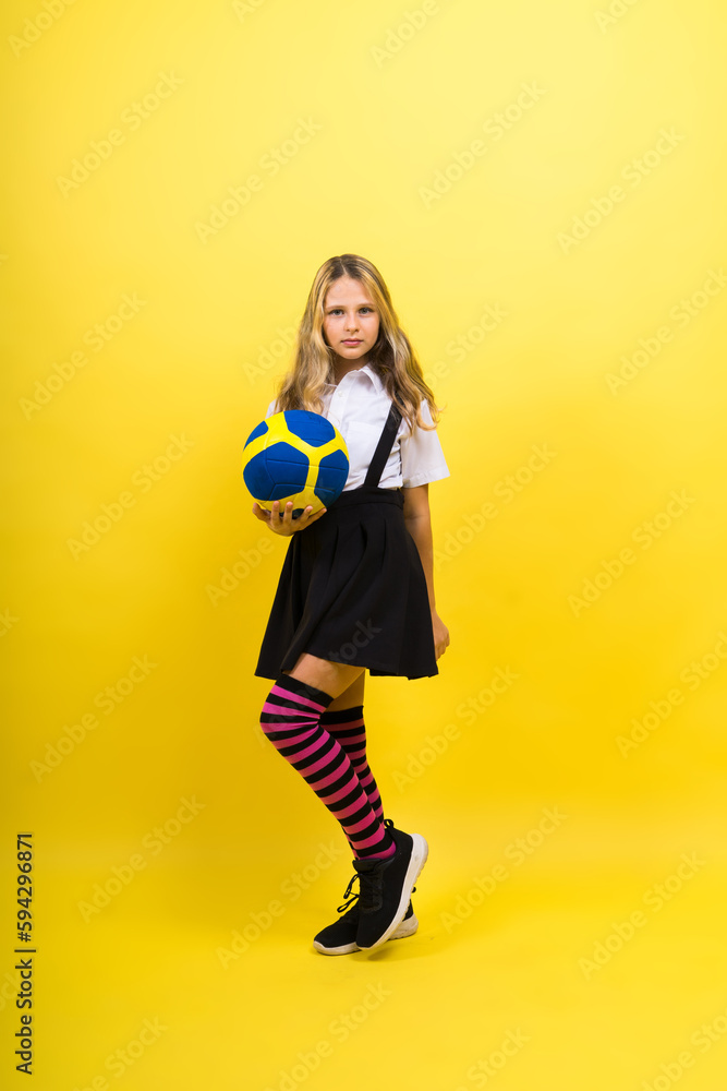 Portrait of a cute eight year old girl in volleyball outfit isolated on red yellow background