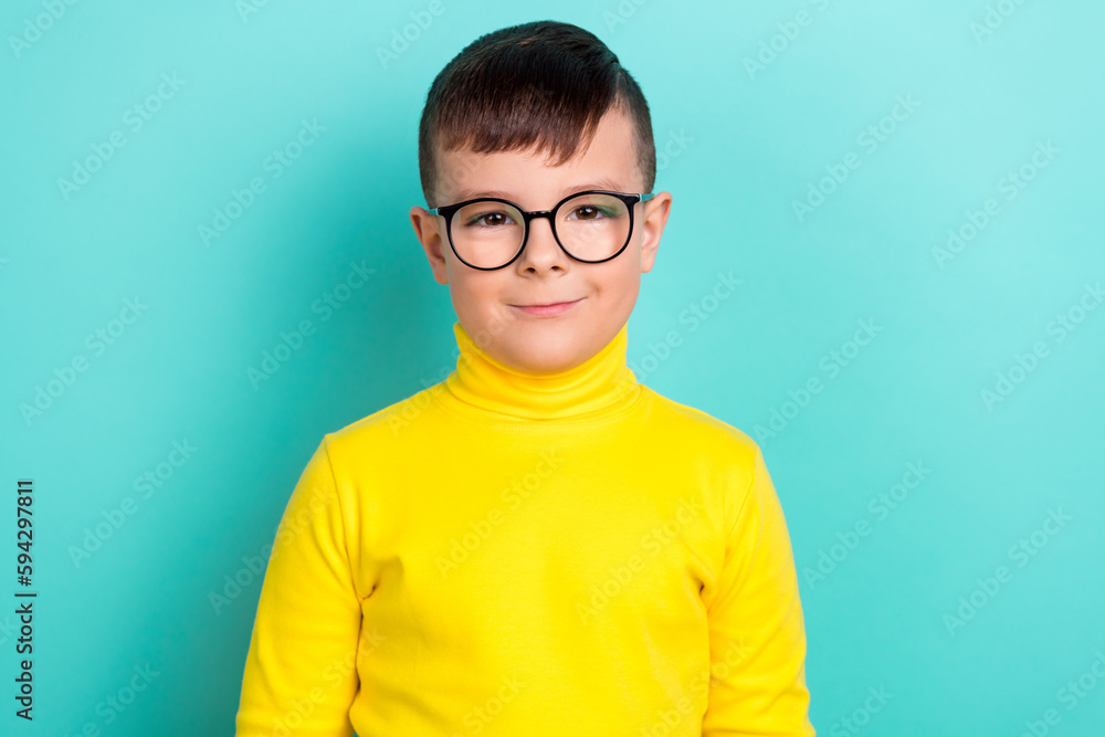Portrait of nice pretty boy look in camera wear glasses bright sweatshirt isolated on cyan color background Portrait of nice pretty boy look in camera wear glasses bright sweatshirt isolated on cyan color background