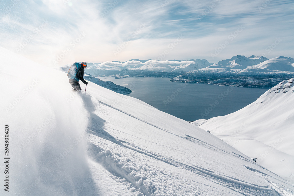 Ski alpinist skiing down the mountain Lyngen Alps, Norway 