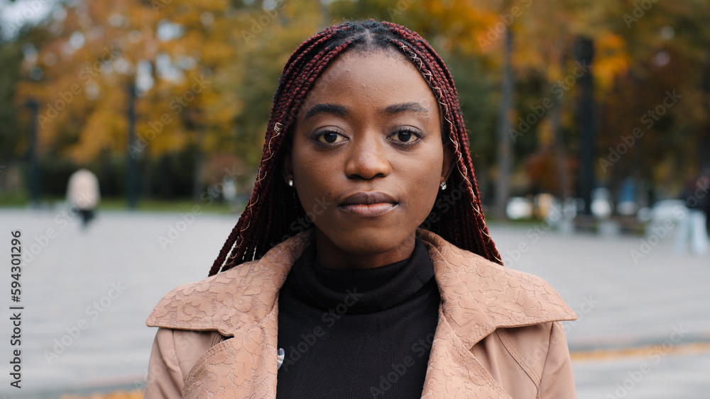 Female portrait close-up young serious pensive beautiful stylish african american woman standing outdoors looking at camera frustrated upset ethnic girl thinking posing with sad expression on street Female portrait close-up young serious pensive beautiful stylish african american woman standing outdoors looking at camera frustrated upset ethnic girl thinking posing with sad expression on street