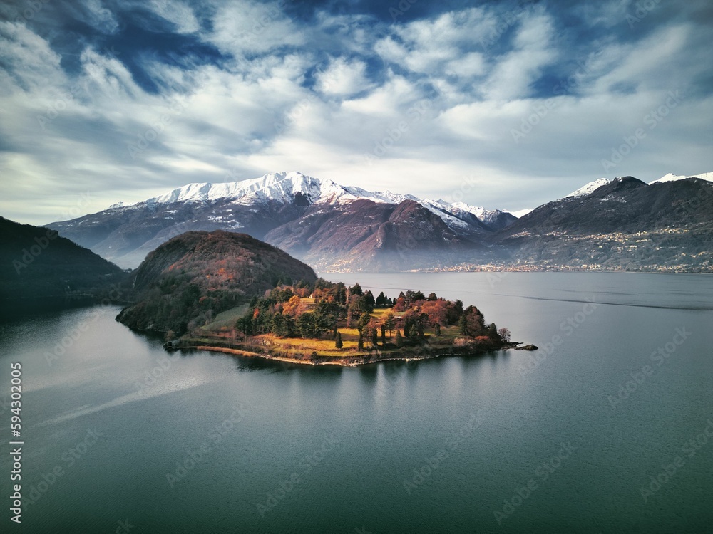 Naklejka premium Drone view of Lake Como surrounded by a town and mountains in the evening in Italy