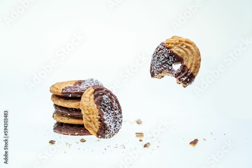 A closeup of half-eaten cookies with coconut and chocolate isolated on a white background
