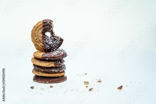 A closeup of half-eaten cookies with coconut and chocolate isolated on a white background