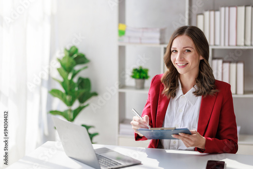 Concept of business investment or working woman, Businesswoman wearing a suit sitting and working on analysis of business investment documents and using computer to analytic business data.