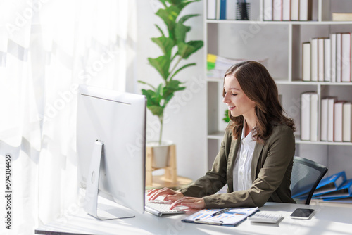 Concept of business investment or working woman,  Businesswoman wearing a suit sitting and working on analysis of business investment documents and using computer to analytic business data.