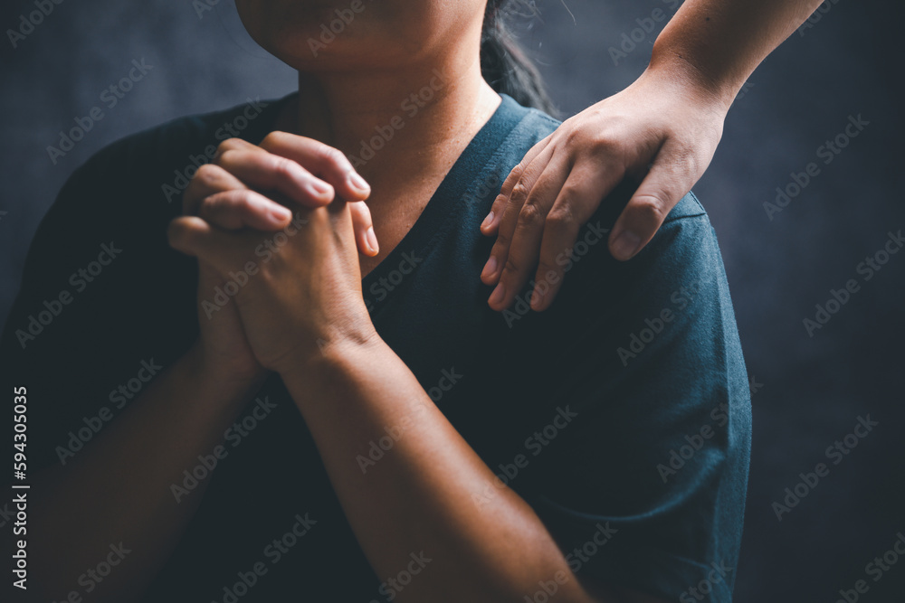 Woman laying hands on a young female christian shoulder to empower and
