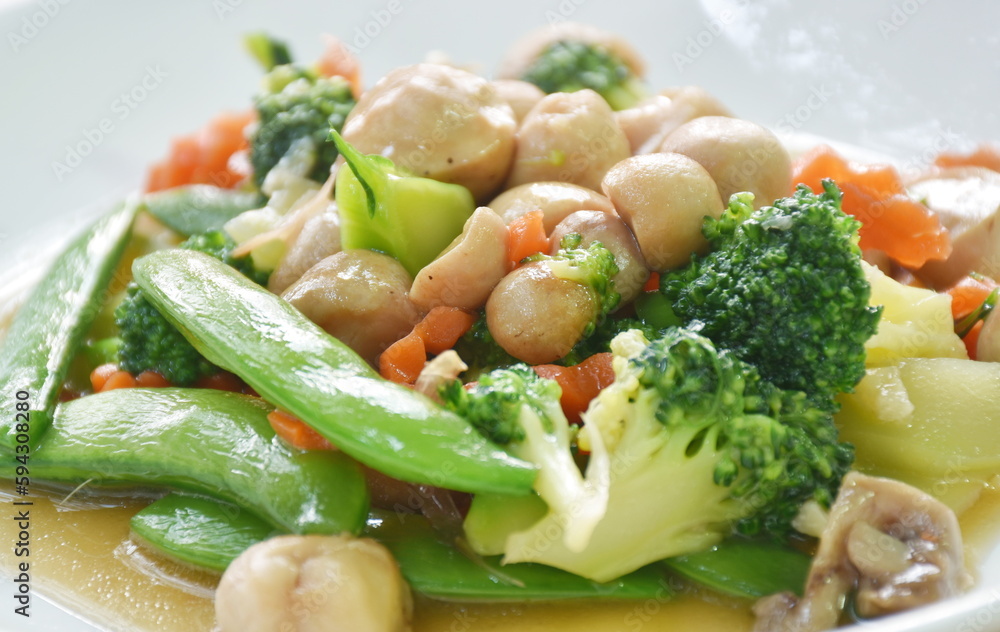 stir fried slice broccoli with green pea and straw mushroom vegetarian food on plate 
