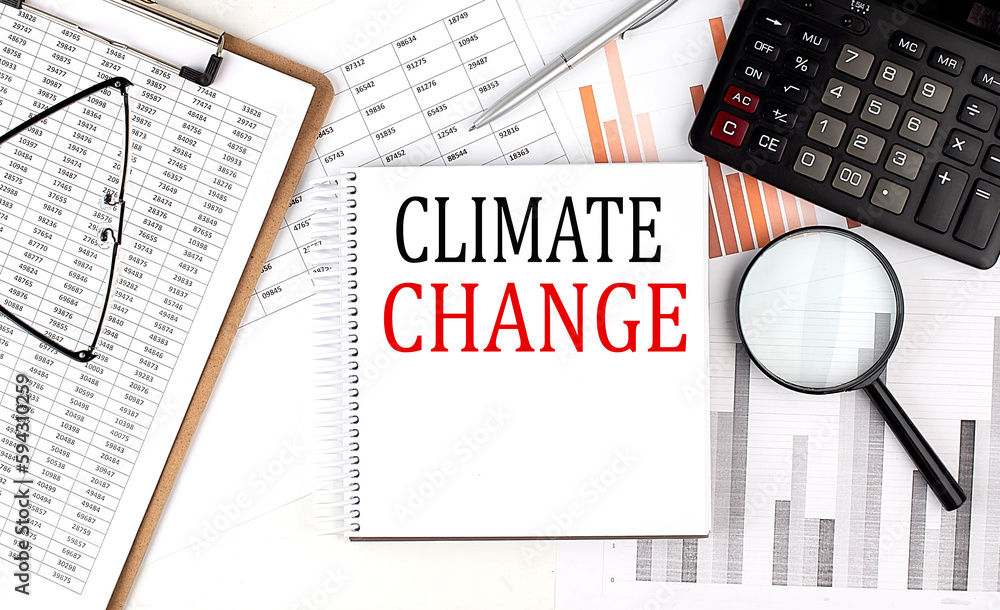 Obraz premium CLIMATE CHANGE text on notebook with clipboard and calculator on a chart background